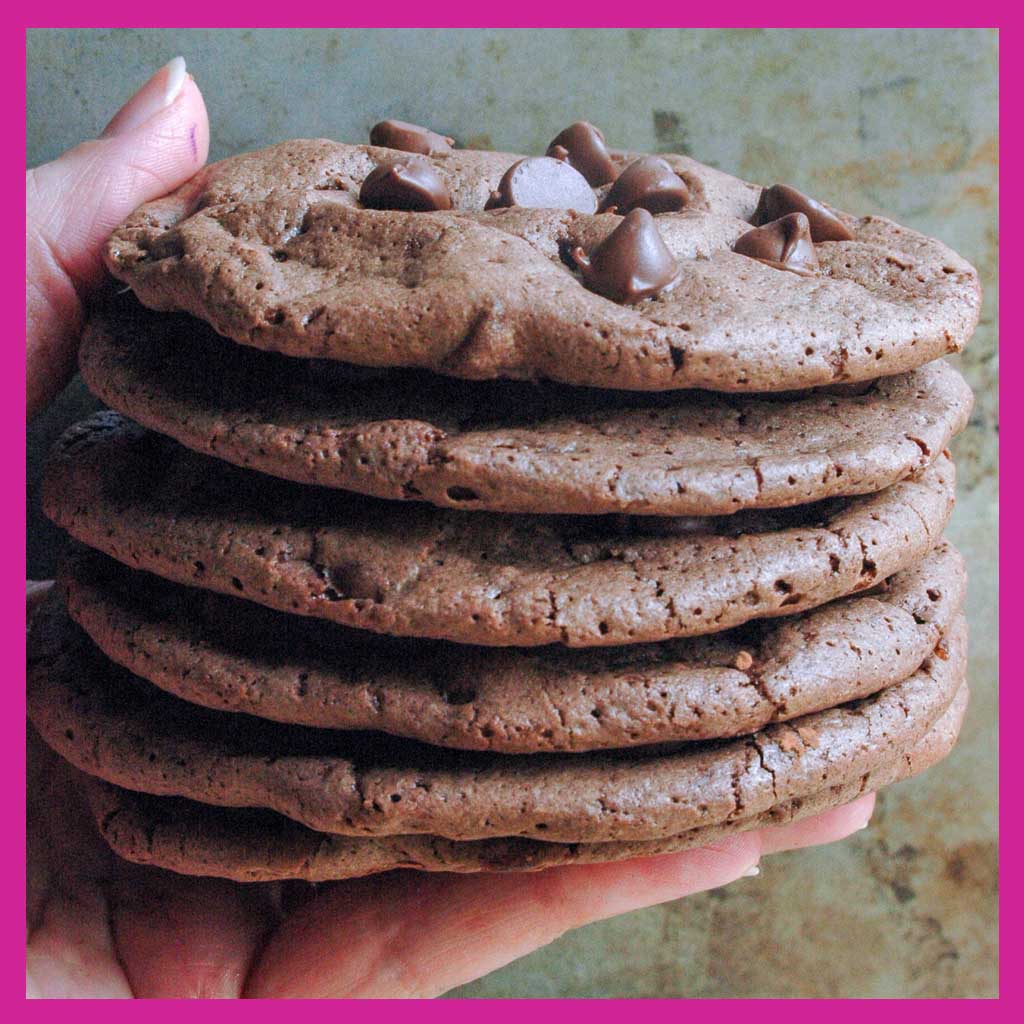 hand holding stack of chocolate chip brownie cookies